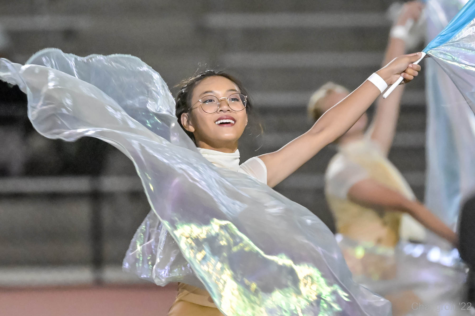 Student holding flags, performing during marching band